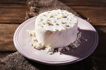 Cottage cheese on plate on sackcloth napkin on wooden