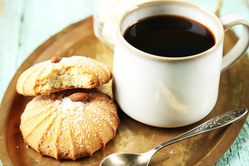 Cup of coffee with tasty cookie on color wooden background