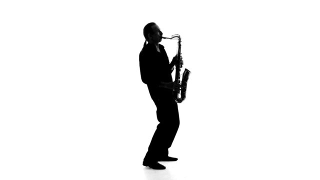 Silhouette of a musician who plays the saxophone on a white