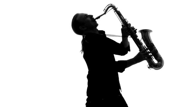 Close up of silhouette of musician playing the saxophone on a