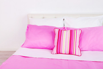 Bed in pink bed linen in room