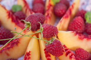 pie with cream decorated peaches and raspberry