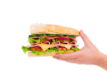 Sandwich with bacon and vegetables in hand.