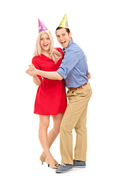 Young Couple With Party Hats Dancing