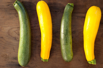 green and yellow zucchini on wooden background
