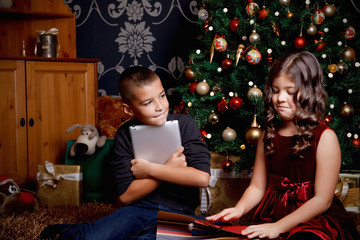 Cute little children opening a Christmas present