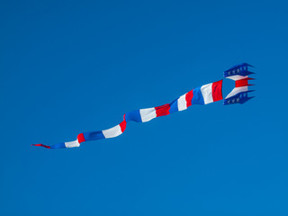 Red, White, and Blue Kite Flying in Cloudless Blue Sky