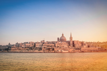 Obraz na płótnie Canvas La Valletta at sunset from the sea - Capital of Malta
