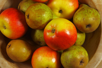 Naklejka na ściany i meble Apples and pears in a wooden bowl.