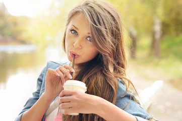 Teenage girl drinking coffee outdoor.
