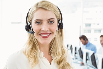 Smiling businesswoman with executives using computers