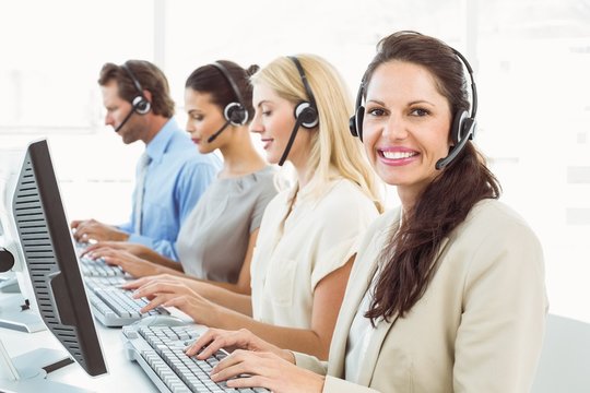 Business people with headsets using computers in office
