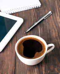 Cup of coffee, tablet and notebook