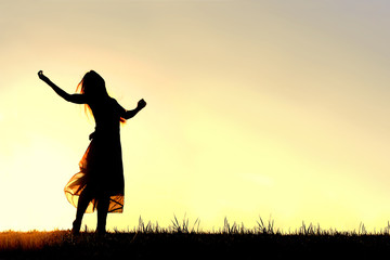 Silhouette of Woman Dancing and Praising God at Sunset - obrazy, fototapety, plakaty