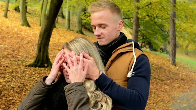 Man surprises woman - young model couple in love - kiss embrace