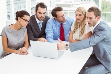Business people using laptop in office