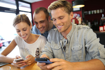 Young people in campus lounge connected on smartphone