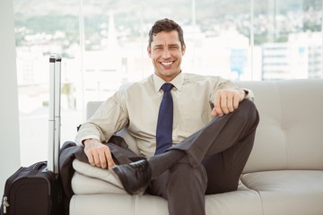 Happy businessman sitting on couch in living room