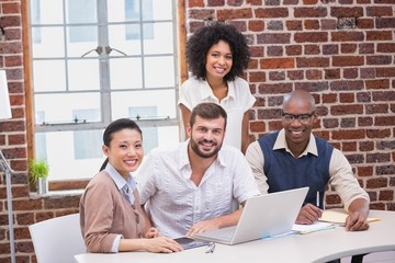 Creative business team using laptop in meeting