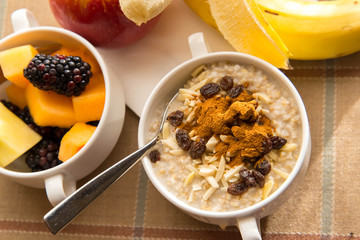 Fresh fruit and oatmeal with healthy toppings for breakfast