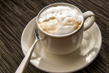morning cup of cappuccino in the morning sun