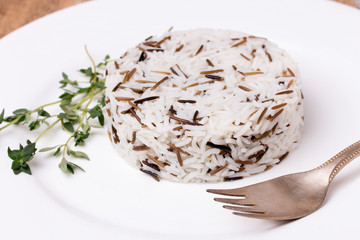 Mixed cooked rice with thyme on white plate