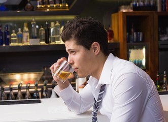 Young man drinking whiskey neat