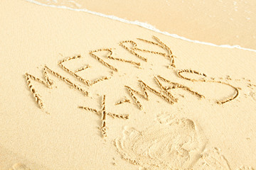 Merry X-Mas written on sand
