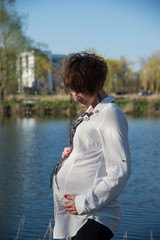 The pregnant girl on walk in city park