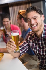 Young man holding pint of beer