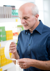 Man checking grocery receipt at store