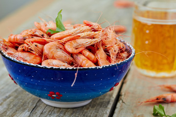 Prepared shrimp on blue plate on wooden background