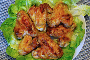 Куриные крылышки на листьях салата.