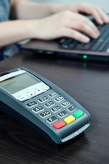 Payment terminal in the office. Man working with laptop in the b