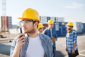 group of builders in hardhats with radio