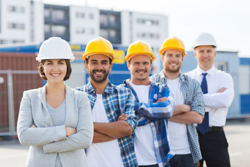 group of smiling builders in hardhats outdoors