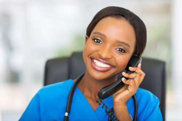 african american female nurse using landline phone