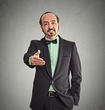 Businessman shaking hands isolated on grey wall background 