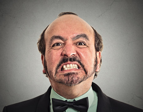 portrait headshot middle aged angry man on grey background 