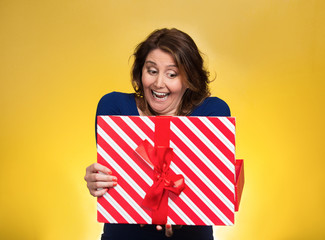 happy excited woman opening red gift box on yellow background 