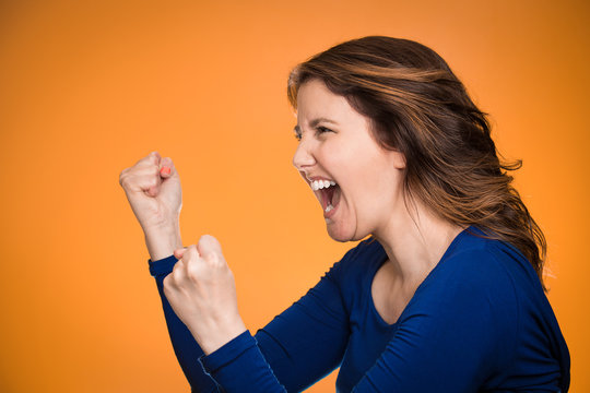 Side profile angry woman screaming on orange background 