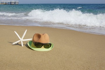 Straw Hat, Sunglasses and  Starfish on the Empty Sea Beach