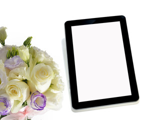 Tablet computer and bouquet of flowers on white background