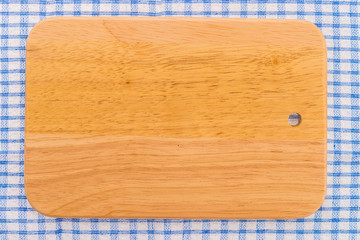 wood cutting board on tablecloth
