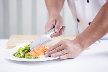 Chef's hands cutting Tomato