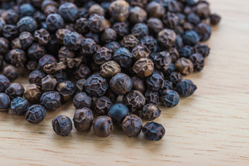 Black pepper on wood background