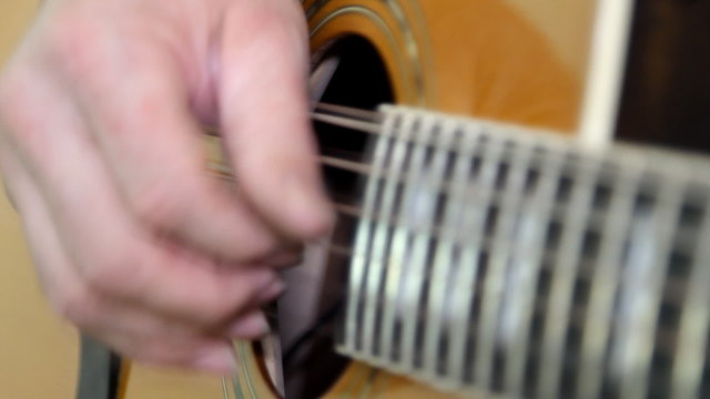 performer playing on the acoustic guitar.
