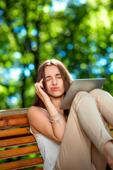 Young woman with digital tablet in the park