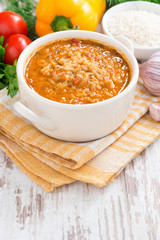 tomato soup with rice, vegetables on a white wooden background