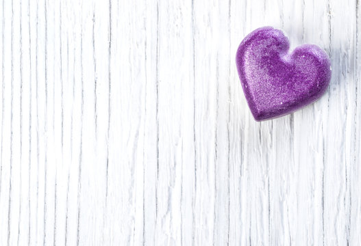 Purple heart on wooden background,